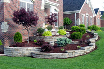 Traditional home with tiered retaining wall for front yard flower beds